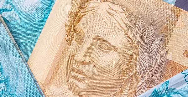 dinheiro, Brasil, Close-up. Cinquenta reais e cem reais de cédulas com foco no símbolo Real.
