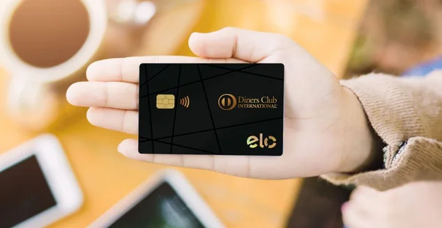 mão segurando um cartão do Elo Diners Club
