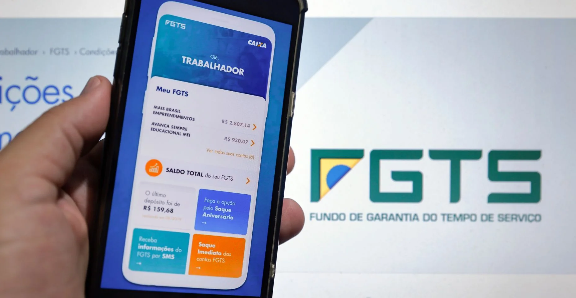 tela do computador e tela do celular com aplicativo FGTS do banco Caixa