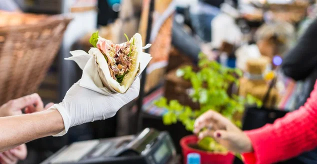 Chef, entregando uma tortilla para um foodie em um mercado de comida de rua