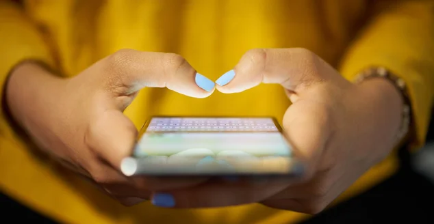 Mulher digitando mensagem de telefone na rede social à noite