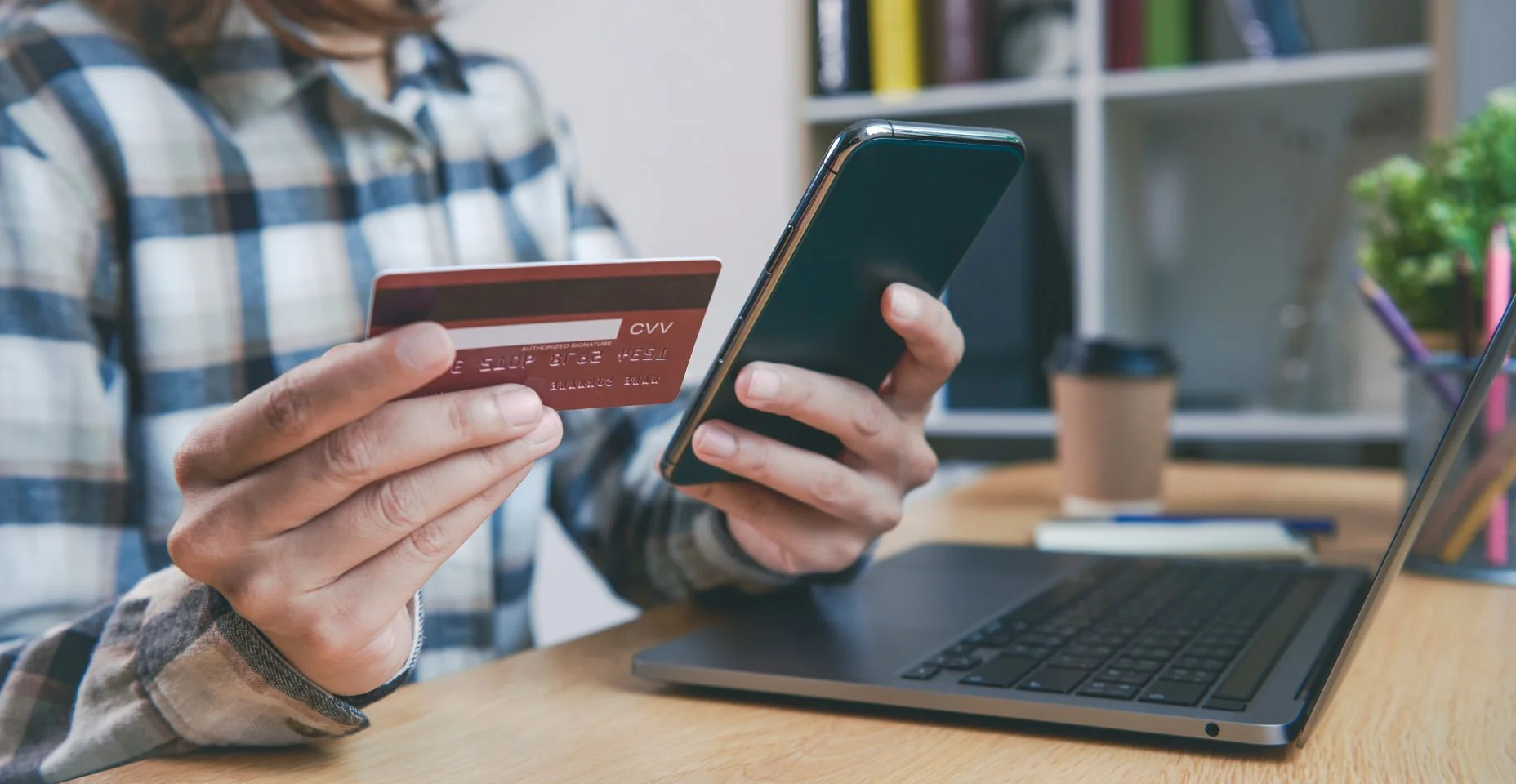 Jovem segurando cartão de crédito e usando telefone inteligente comprando compras online. conceito de tecnologia bancária móvel de aplicativo.