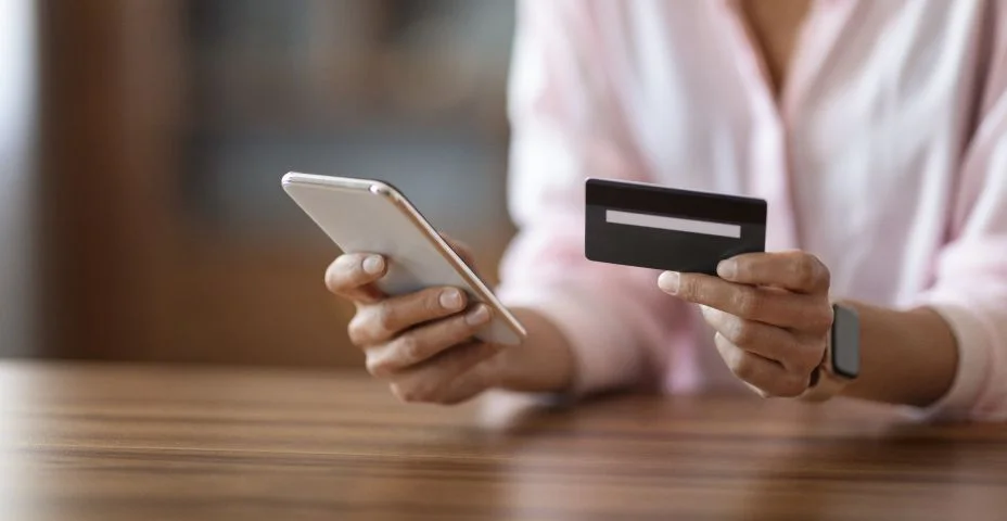 Mulher irreconhecível segurando telefone celular e cartão de crédito, espaço de cópia