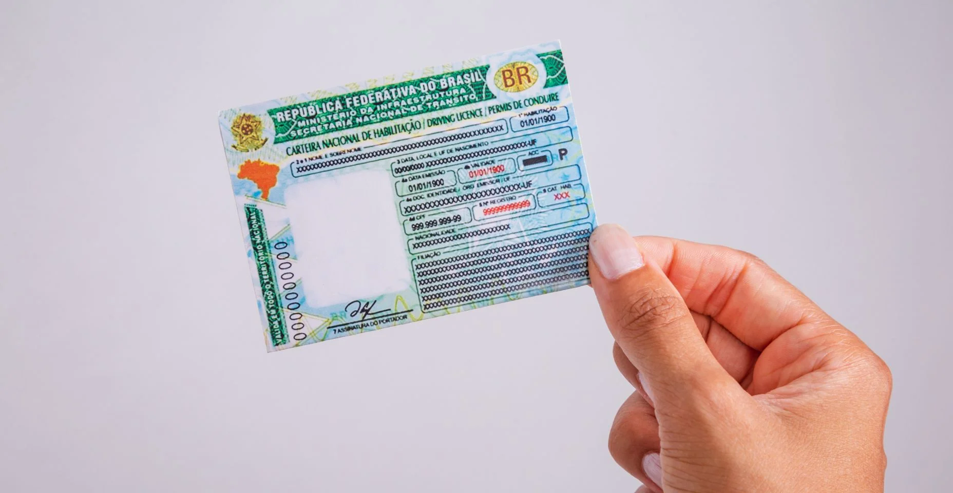 Mão segurando carteira de motorista. Documento brasileiro.