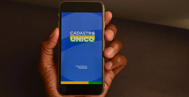 pessoa segurando um celular com o Cadastro Único app aberto