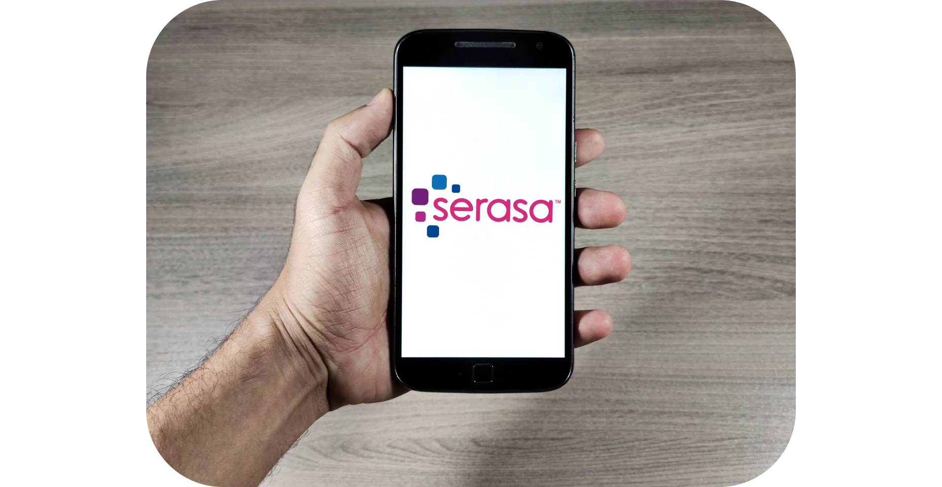 mão segurando celular com logo da Serasa