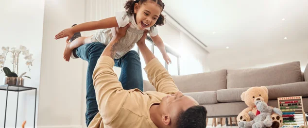 pai e menina brincando em uma casa com liberdade, se unindo e desfrutando de tempo de qualidade juntos. Felicidade, sorriso e criança a voar nos braços dos pais no chão num fim de semana em casa