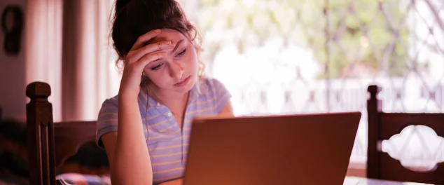 mulher olhando para o computador preocupada