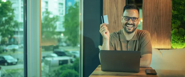 rapaz segurando cartão de credito