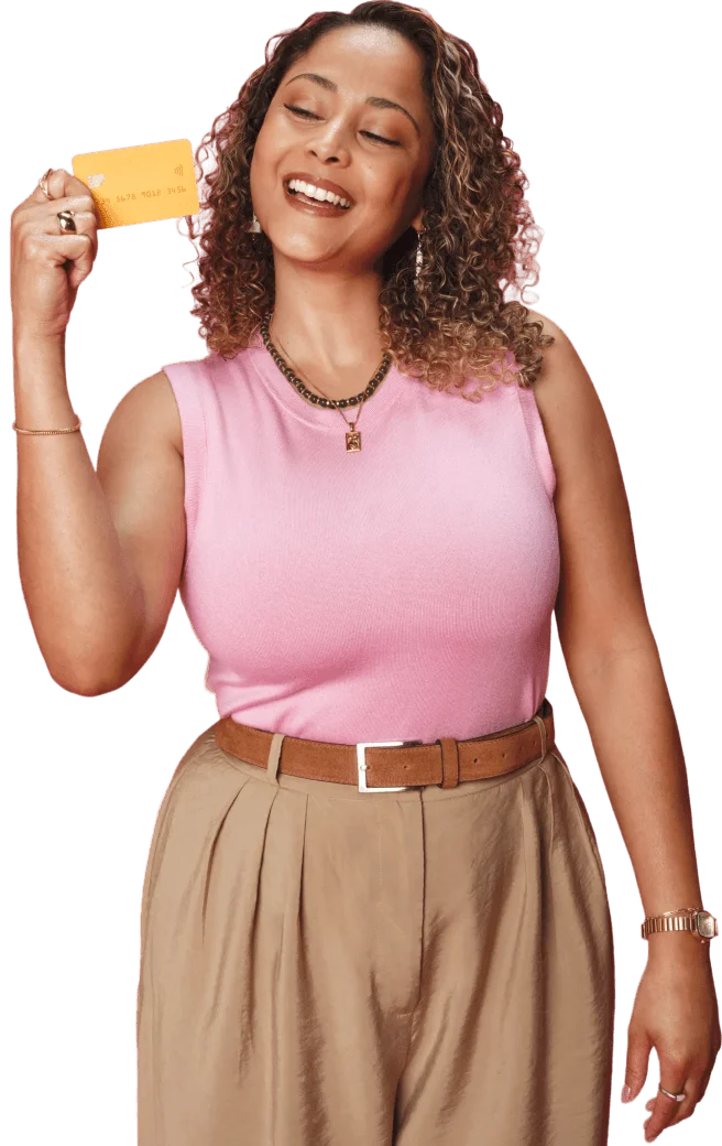 Mulher de camisa rosa segurando cartão próximo ao rosto.