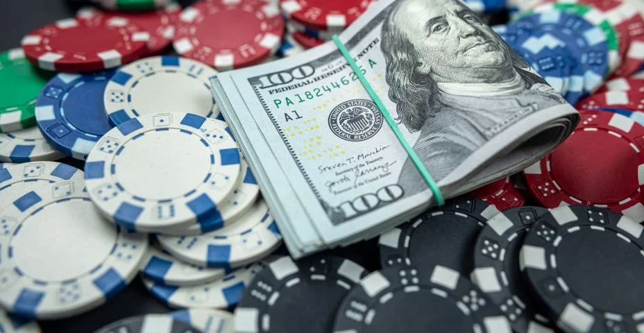 Fichas de poker e notas de dólar na mesa do casino