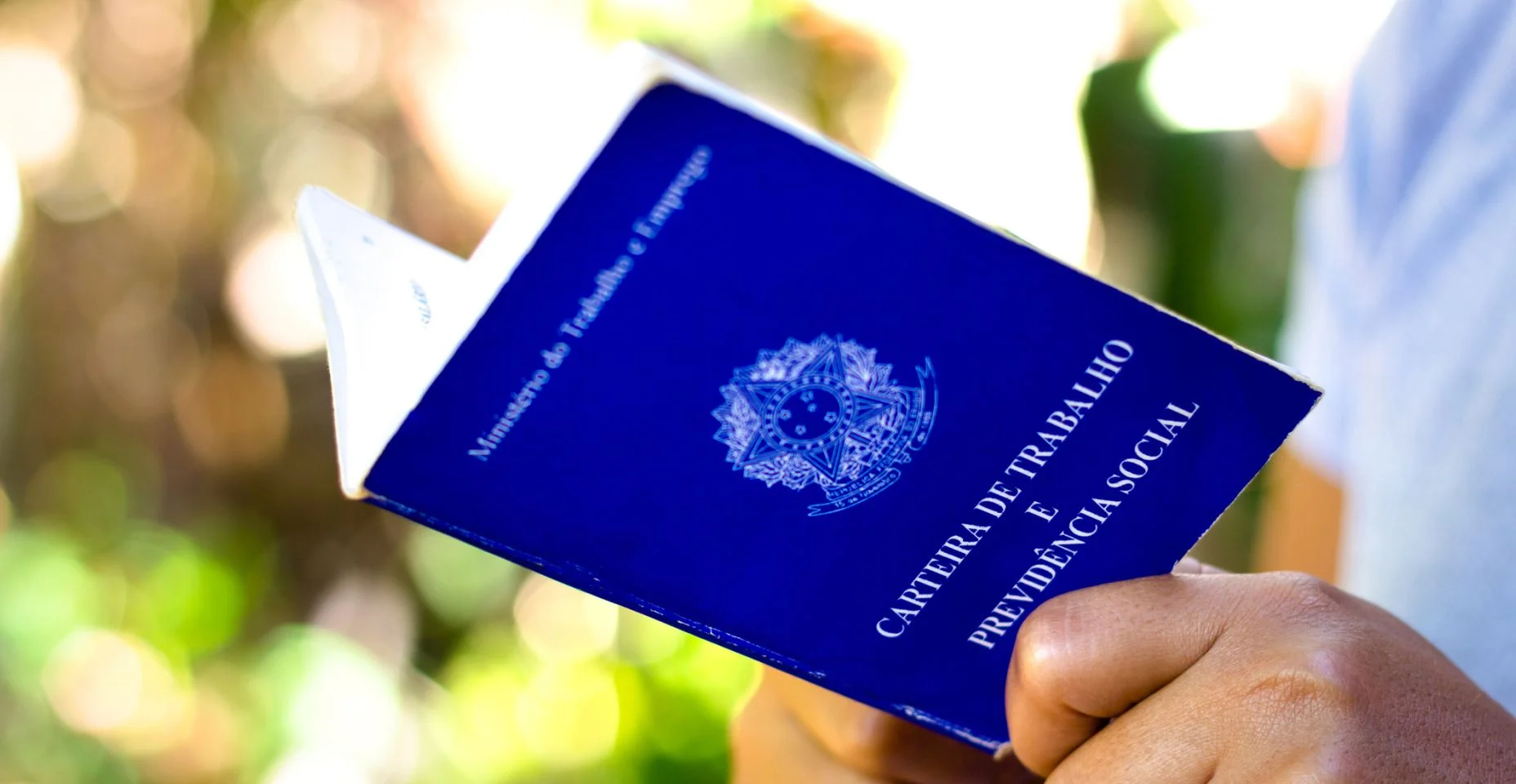 Homem segura documento brasileiro de trabalho e previdência social (Imagem: Getty Images)