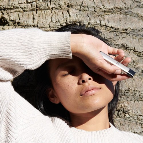 Woman blocking the sun holding a Pax Era