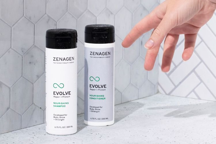 Hand reaching for Evolve Nourishing Shampoo and Conditioner