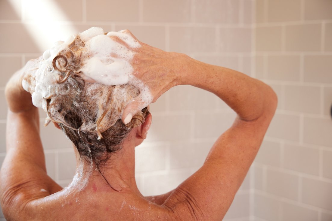 Woman washing hair in shower