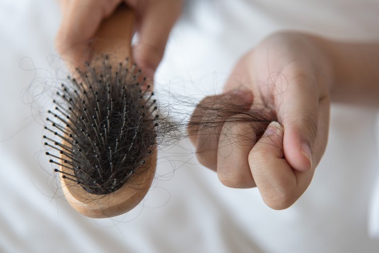 Women's hair coming out into her hair brush