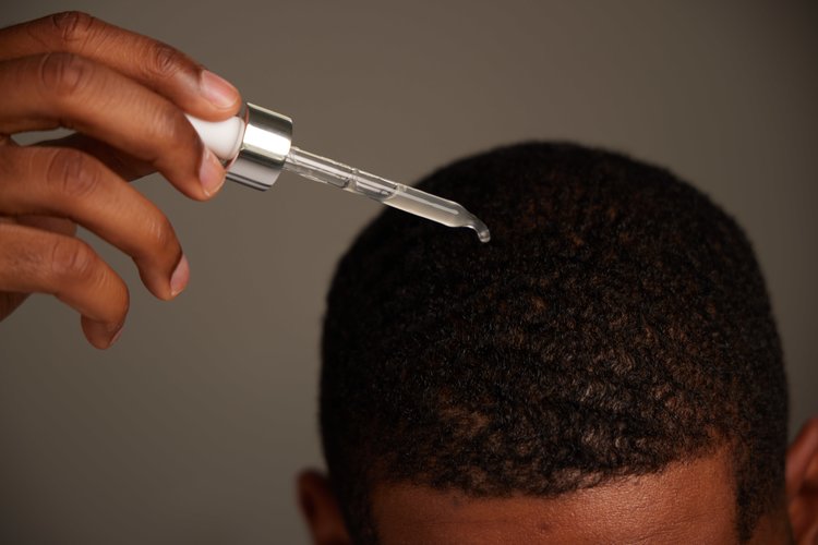 African American male applying Zenagen Thickening Hair Serum
