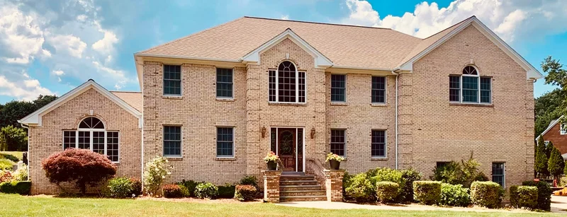Two-story brick home with a landscaped front lawn