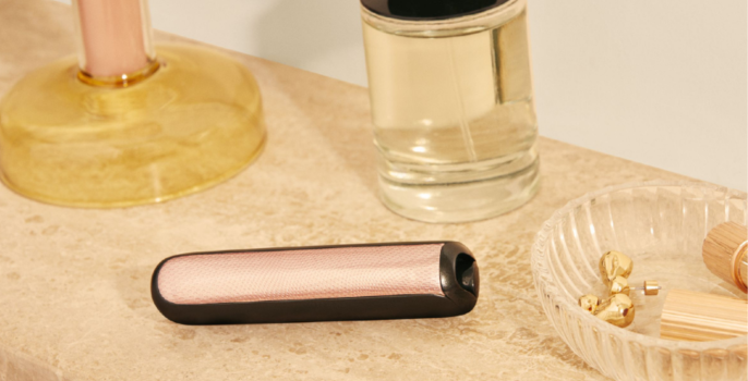 Ploom AURA front panels with Rose Gold Augmented Pattern placed on a dressing table.