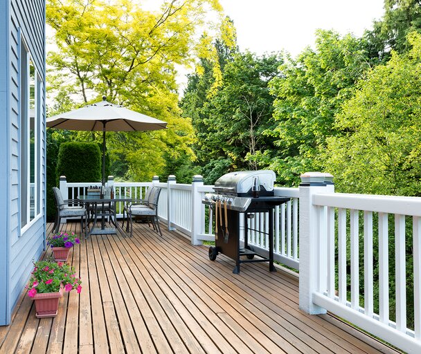 Backyard with white rails, bbq and outdoor table