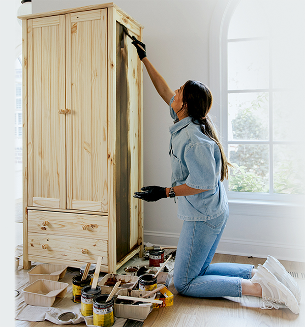 Lady staining a cabinet