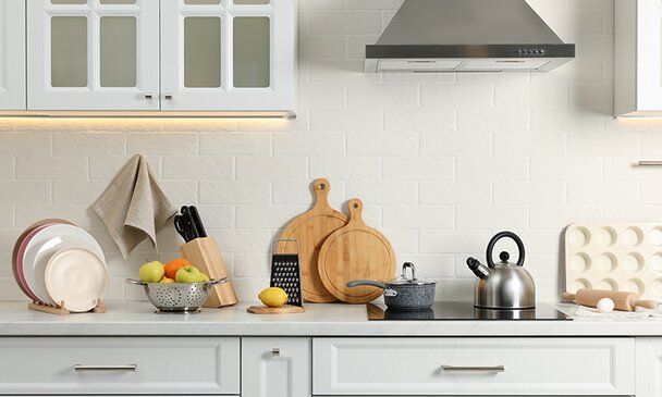 Countertop with stove, products and cooking utensils in kitchen