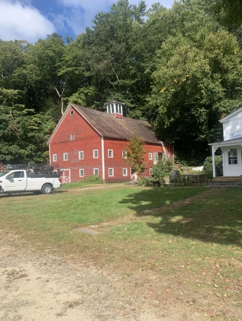 Before — Red cupola barn before and with a bright coated metal roof after restoration