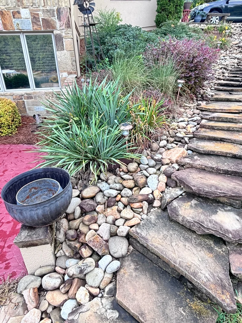 Natural stone steps and river-rock garden beside a home