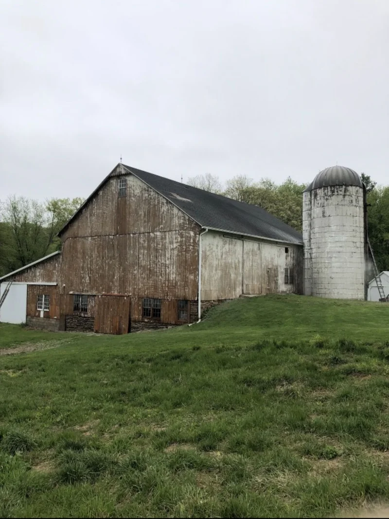 Before — Weathered barn and silo before and freshly painted white exterior after restoration