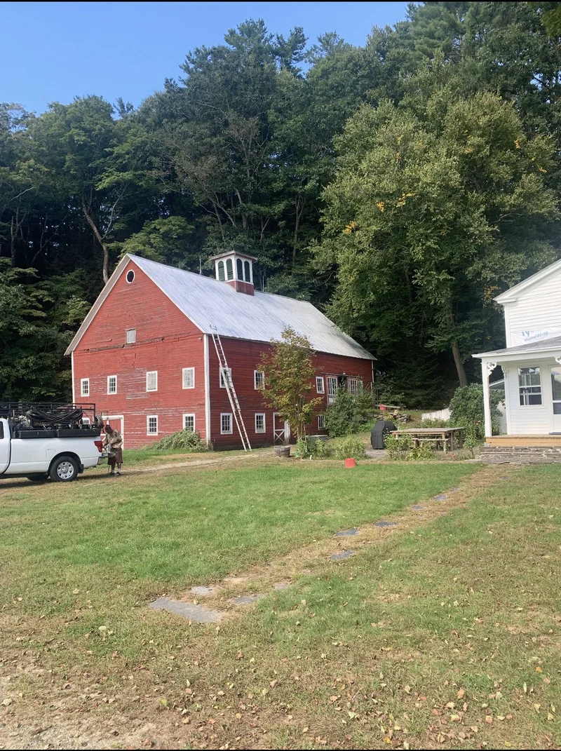 After — Red cupola barn before and with a bright coated metal roof after restoration
