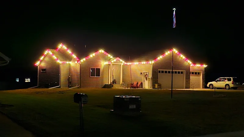 Perham-area home with colorful Christmas lights tracing multiple rooflines