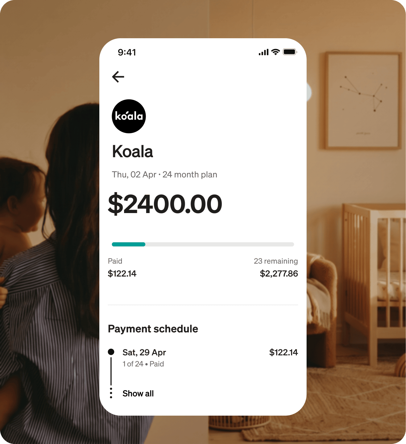 Parent holding a child at home, with the Afterpay app showing a $2,400 Koala order on a 24 month plan.