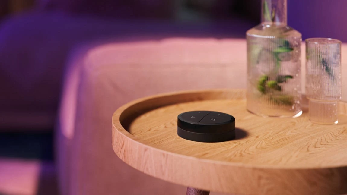 Philips Hue Tap Dial Fernbedienung liegt auf Beistelltisch