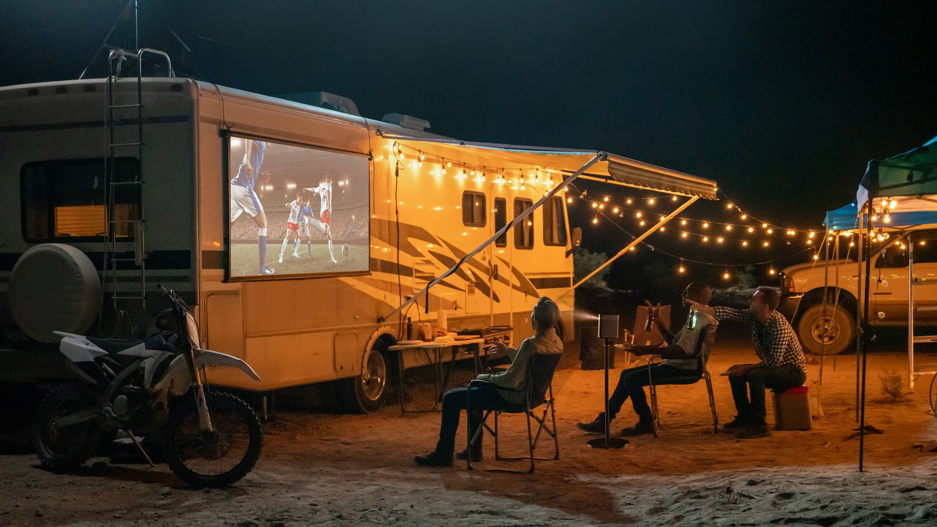 Freunde schauen beim Camping Fußball mit XGIMI Beamer