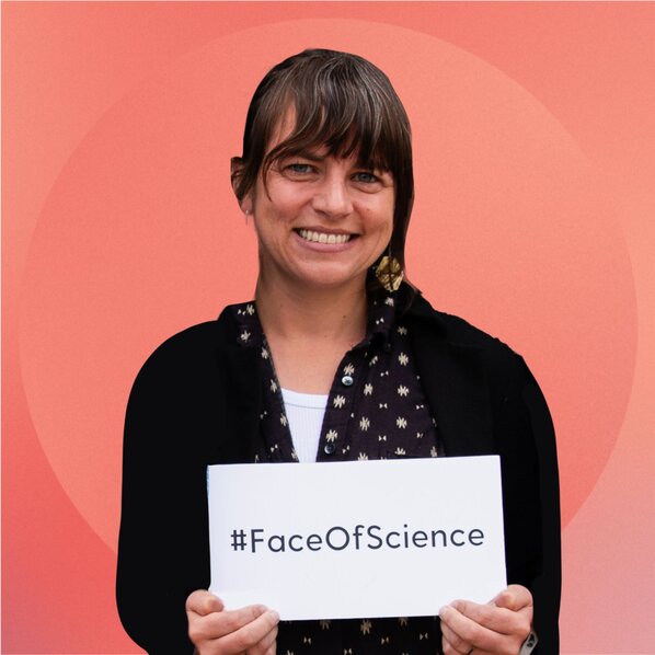 Jen Lindwall holding a sign with #FaceOfScience