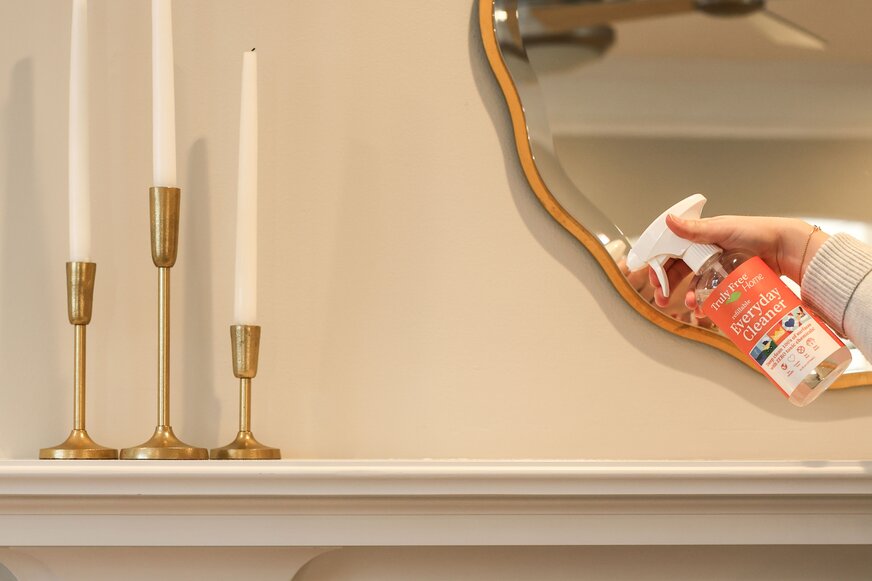 Spraying Truly Free Home Everyday Cleaner on mantle.