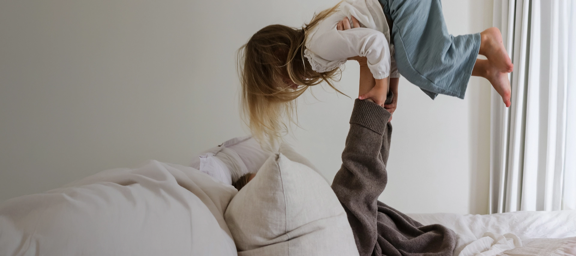 Truly Free Laundry Wash and refill pouch in a laundry room, with a woman and baby in the background.