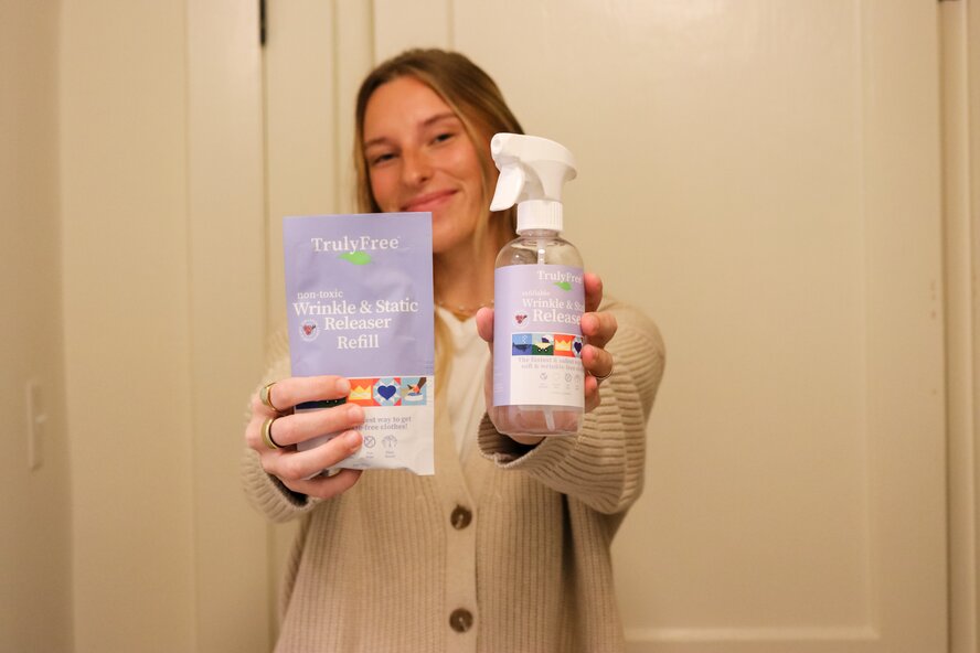 Woman holding Truly Free Home wrinkle release spray