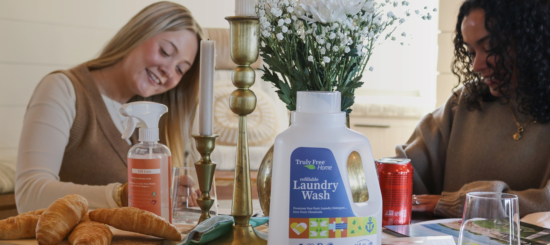 Truly Free Laundry Wash and refill pouch in a laundry room, with a woman and baby in the background.