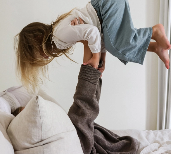 Truly Free Laundry Wash and refill pouch in a laundry room, with a woman and baby in the background.