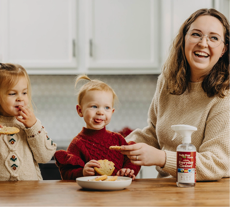 Truly Free Laundry Wash and refill pouch in a laundry room, with a woman and baby in the background.