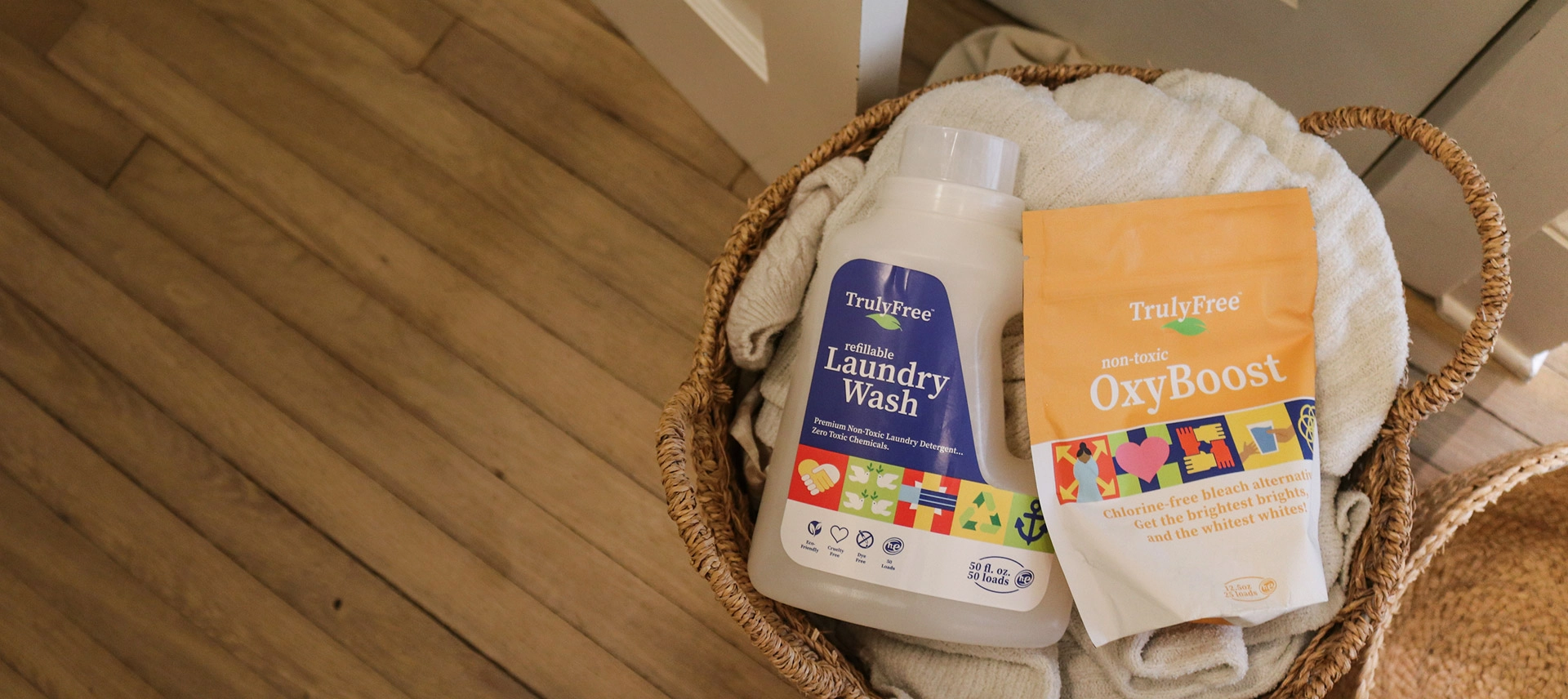 Truly Free Laundry Wash and refill pouch in a laundry room, with a woman and baby in the background.