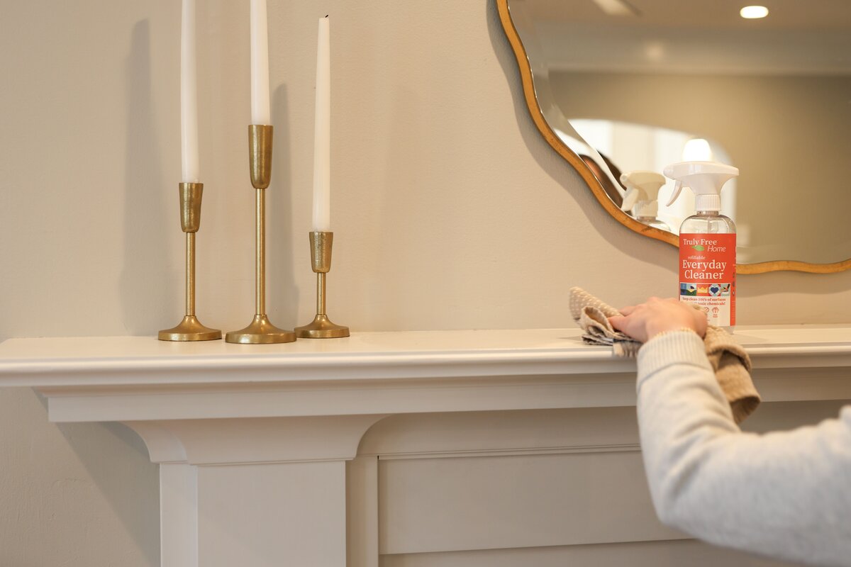 Wiping down a mantle with Truly Free Home Everyday Cleaner
