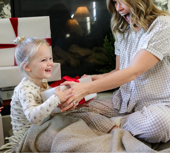 Truly Free Laundry Wash and refill pouch in a laundry room, with a woman and baby in the background.