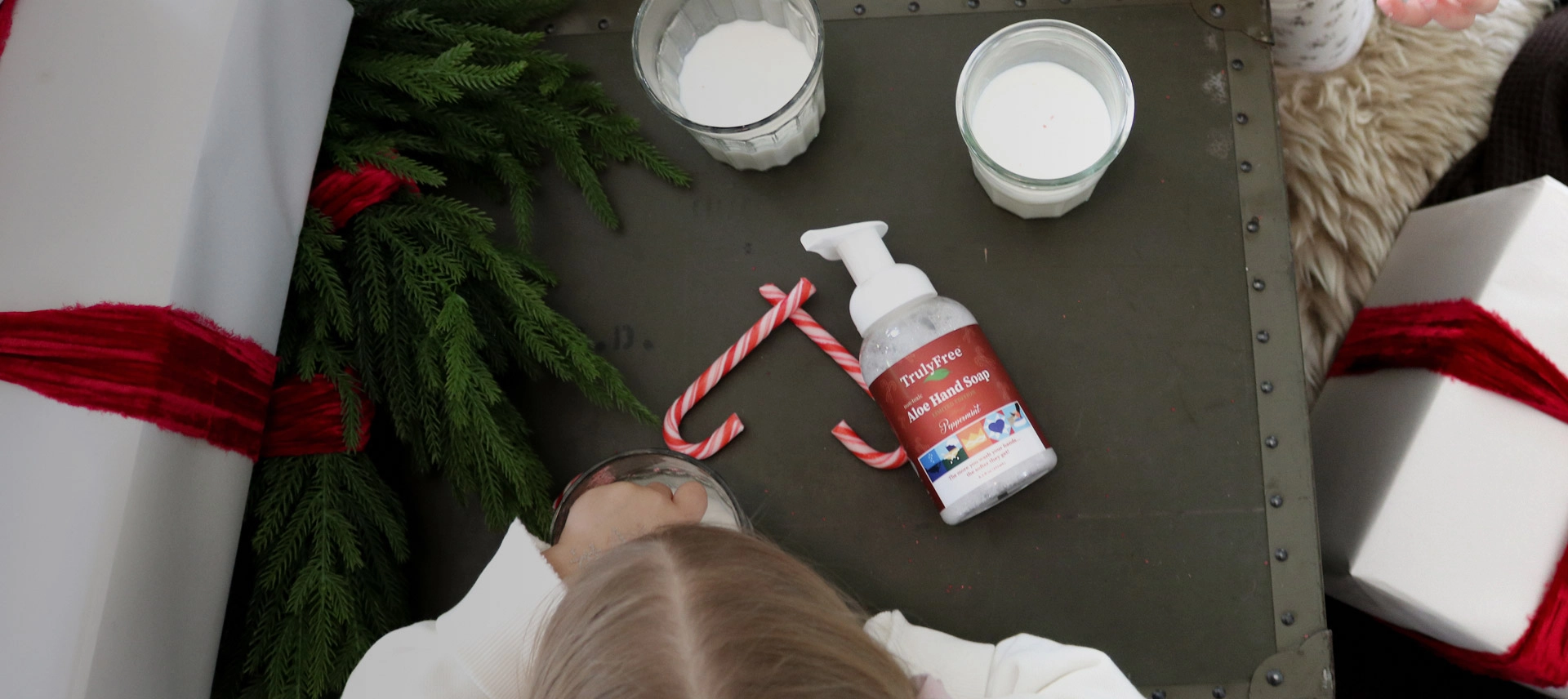 Truly Free Laundry Wash and refill pouch in a laundry room, with a woman and baby in the background.