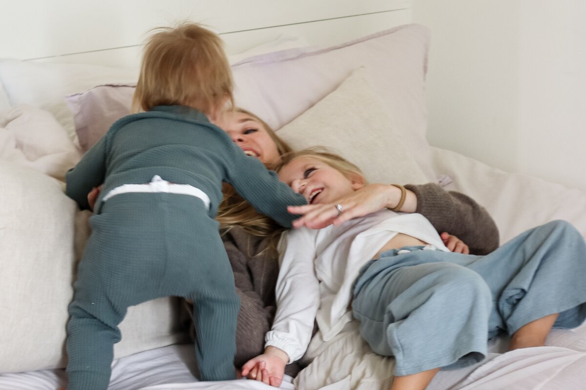 Mom and kids snuggling in bed