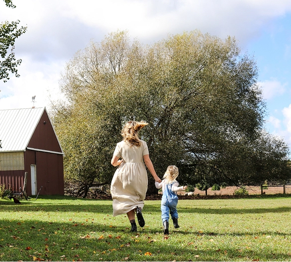 Truly Free Laundry Wash and refill pouch in a laundry room, with a woman and baby in the background.