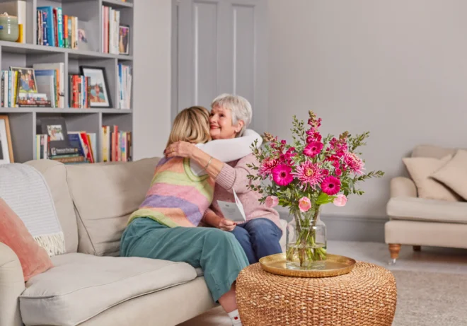 A daughter gifting her mother a Freddie's Flowers bouquet