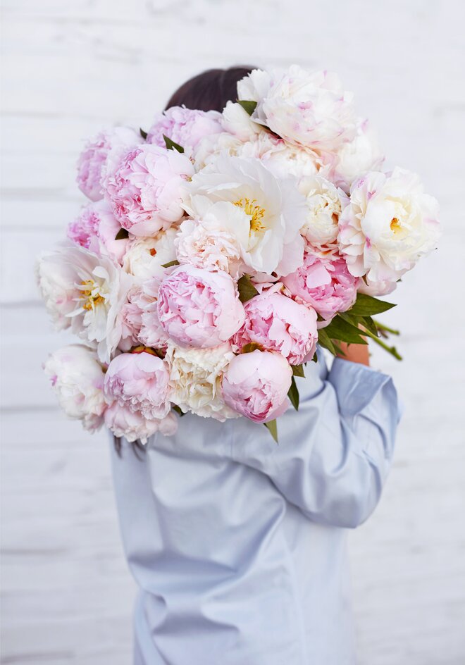 Someone carrying a bouquet of peonies