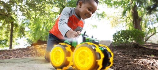 Boy playing with toy tractor outdoors
